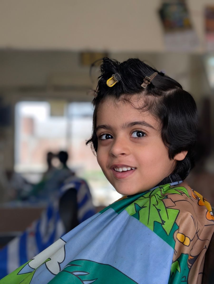 Enfant souriant pendant une coupe de cheveux