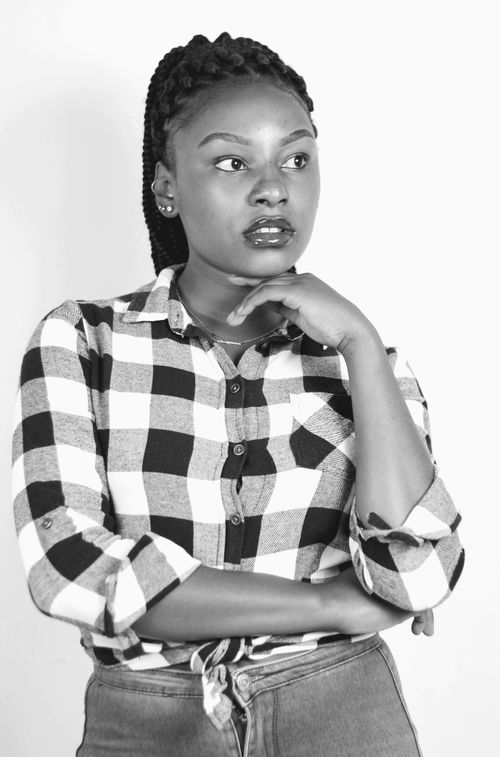 Free A black and white portrait photo of a woman in a plaid shirt contemplating. Stock Photo