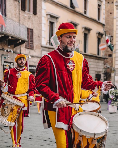 Free Drummers in traditional Renaissance costumes perform in a European street festival. Stock Photo