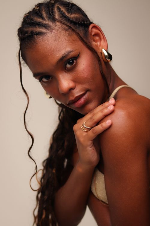 Free A striking portrait of a woman with braided hairstyle and stylish accessories, exuding confidence and grace. Stock Photo