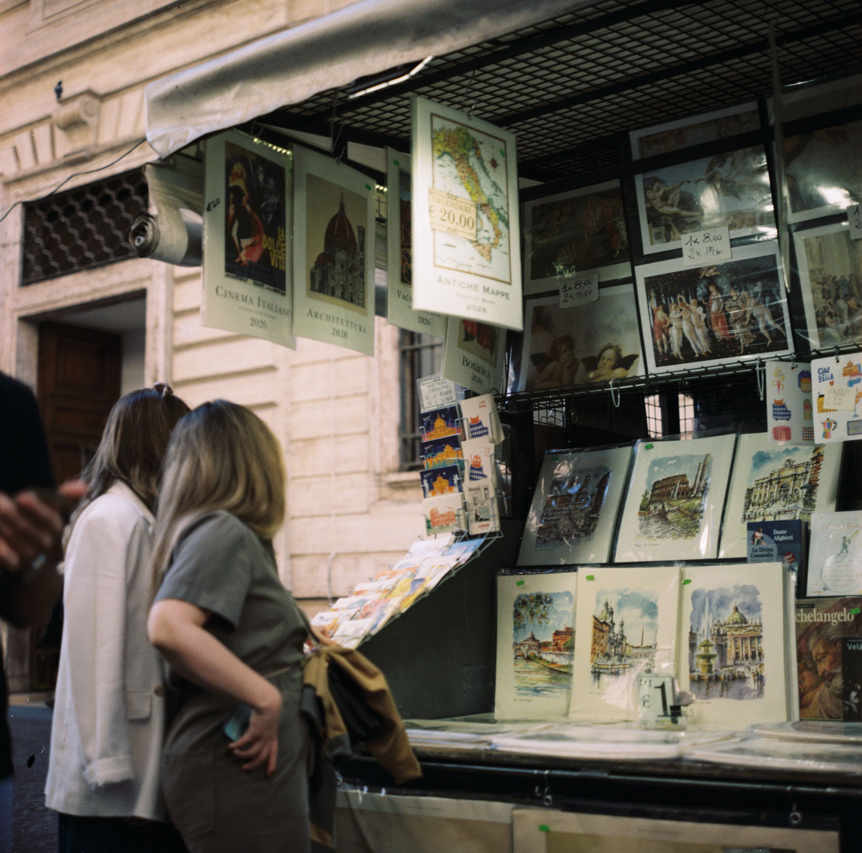 Explore a vibrant street art market in Rome, showcasing a variety of posters and prints with local flair.