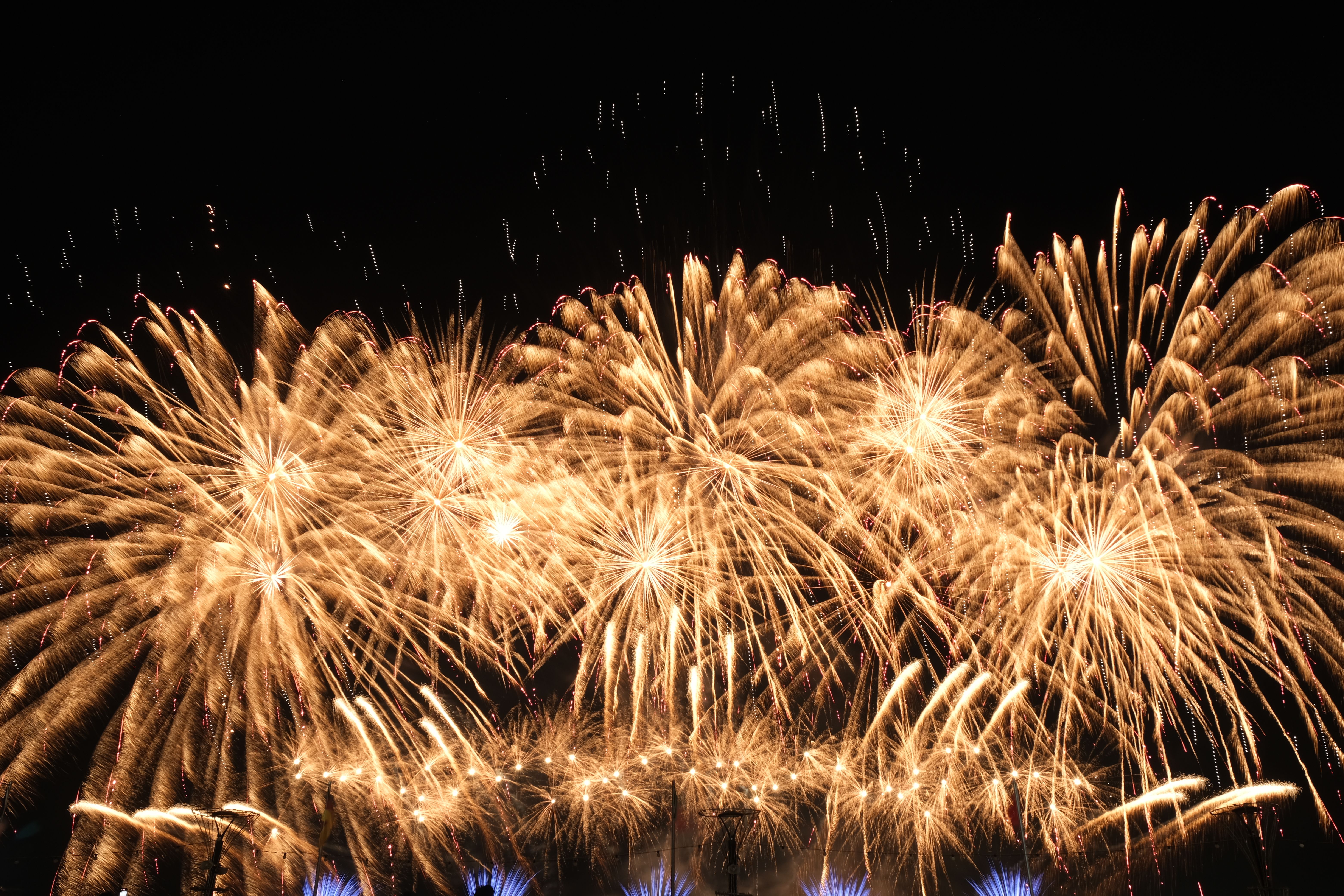 A breathtaking display of golden fireworks illuminating the night sky, creating a festive and celebratory atmosphere.