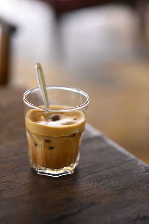 Free A refreshing glass of iced coffee with a spoon on a wooden table. Stock Photo