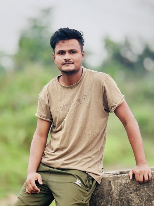 Free Portrait of a young man in casual attire posing outdoors, conveying a relaxed and confident demeanor. Stock Photo