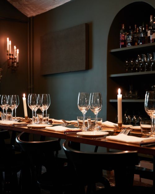 Free A sophisticated dining setup with candles and wine glasses in a dimly lit restaurant setting. Stock Photo