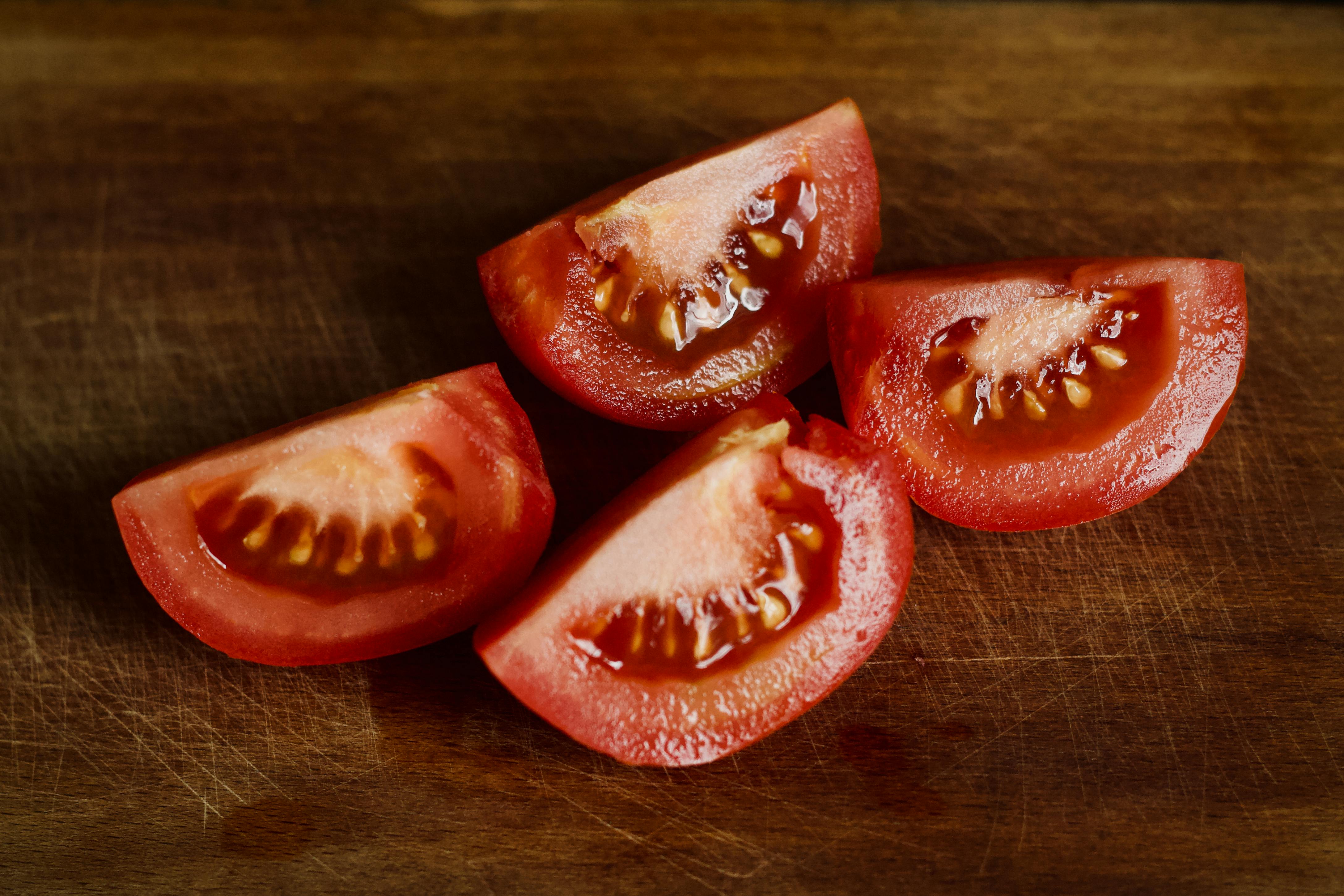 Thick tomato slices on a chopping board ready for lunch