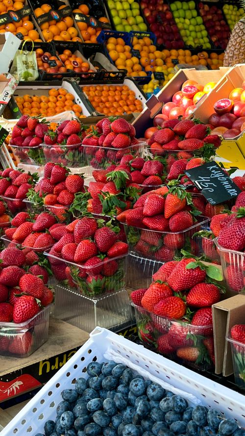 Free Colorful arrangement of fresh strawberries, blueberries, and citrus fruits on a market stall. Stock Photo
