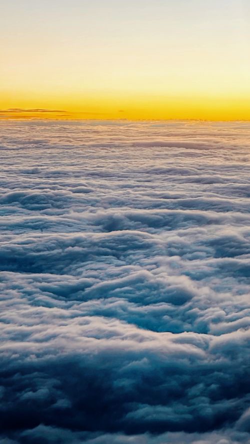 Free Captivating aerial photograph of sunset clouds with a vibrant, colorful sky above. Stock Photo