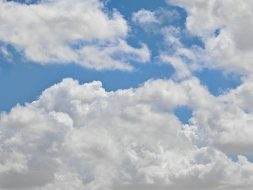 Free Vast blue sky filled with fluffy white clouds creating a serene and peaceful scene. Stock Photo
