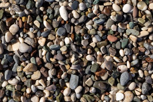 Free A detailed close-up of assorted pebbles and stones with diverse colors and textures. Stock Photo