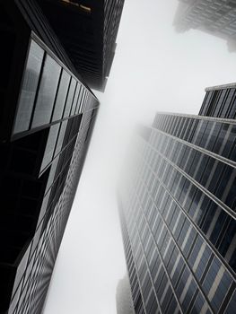 A foggy view looking up at Chicago skyscrapers, blending into the mist.