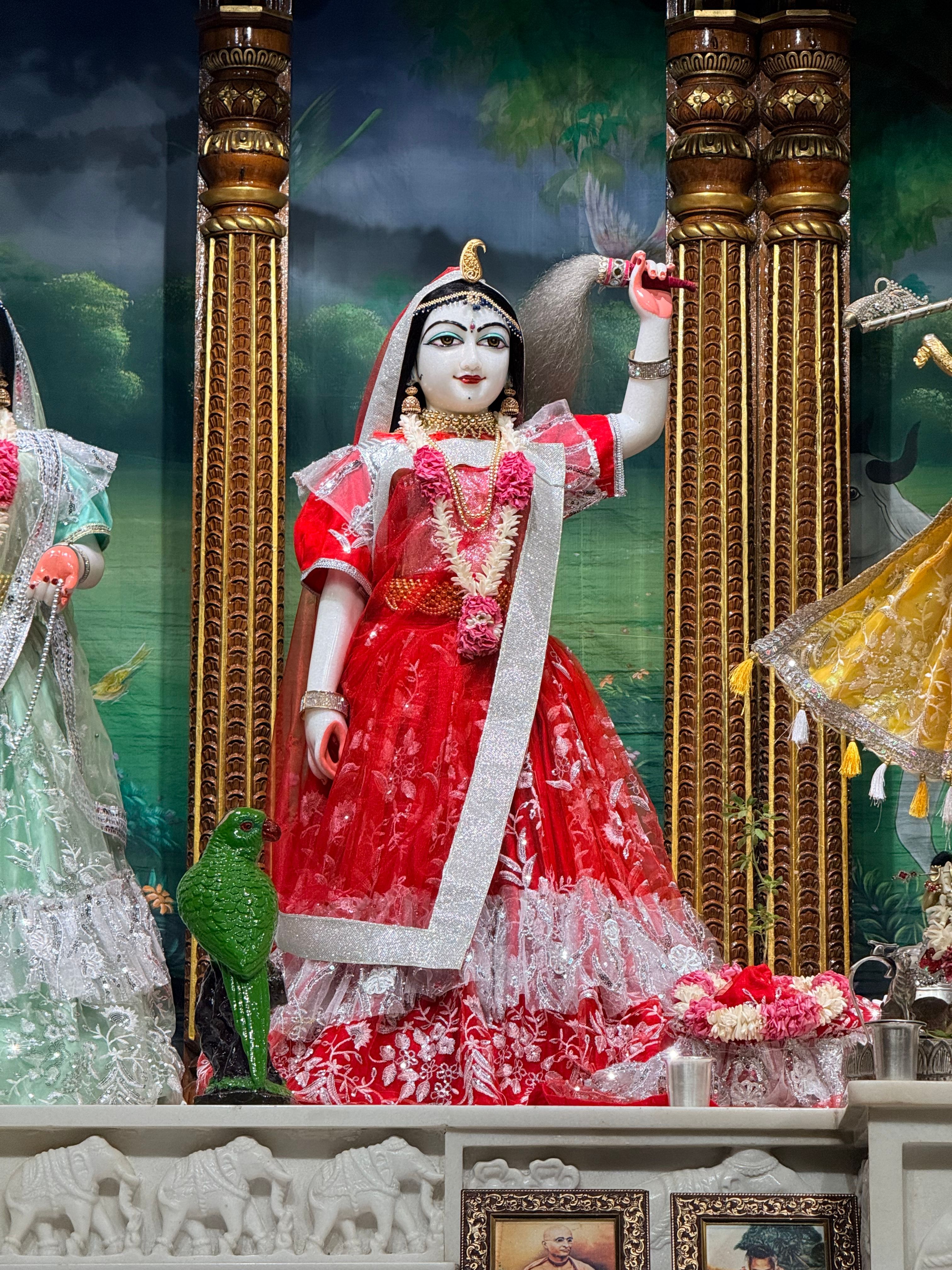 A vibrant statue of a goddess in red attire at a temple in Tirupati, showcasing Indian cultural heritage.
