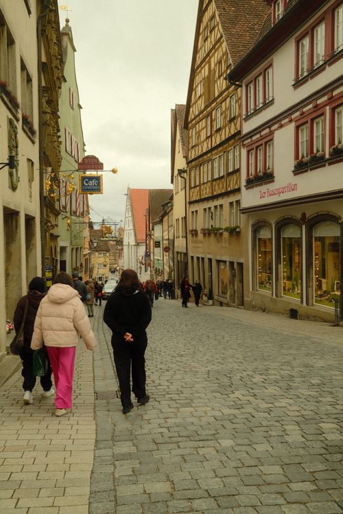 Free Charming medieval street in Rothenburg ob der Tauber, Germany, featuring half-timbered houses and strolling tourists. Stock Photo
