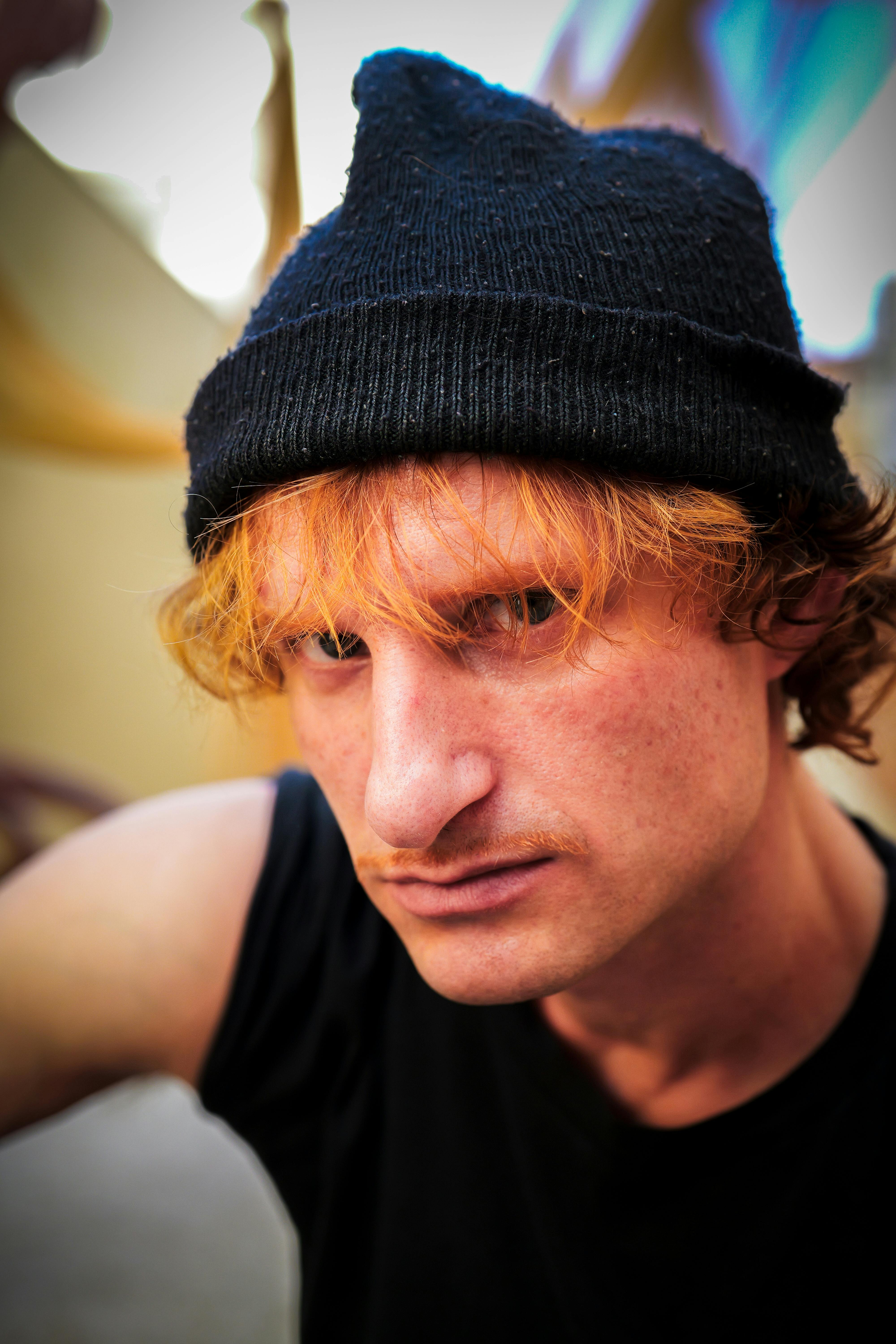 Close-up portrait of a person wearing a black beanie and black shirt in São Paulo.