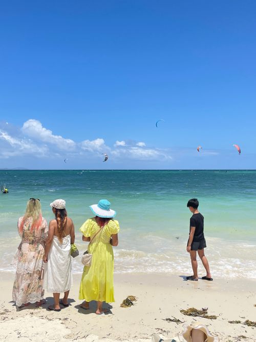 Free A vibrant beach day with people enjoying the sea and kite surfers in Boracay, Philippines. Stock Photo
