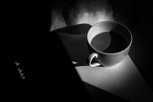 Free A moody black and white photo of a coffee cup in dramatic lighting. Stock Photo