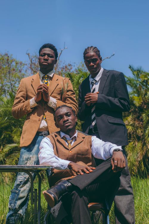 Free Three young men in formal attire pose confidently outdoors in Accra, Ghana. Stock Photo