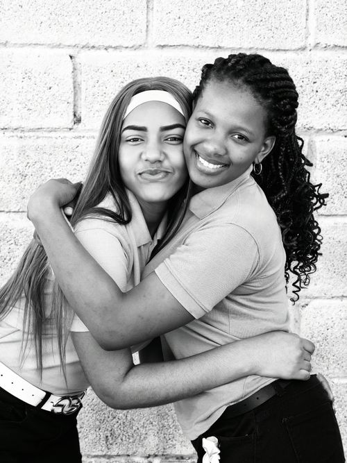 Free Heartwarming black and white portrait of two teenage friends embracing, showcasing joy and friendship. Stock Photo