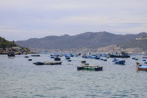 Free Multiple fishing boats on a serene mountain lake under a bright sky. Stock Photo