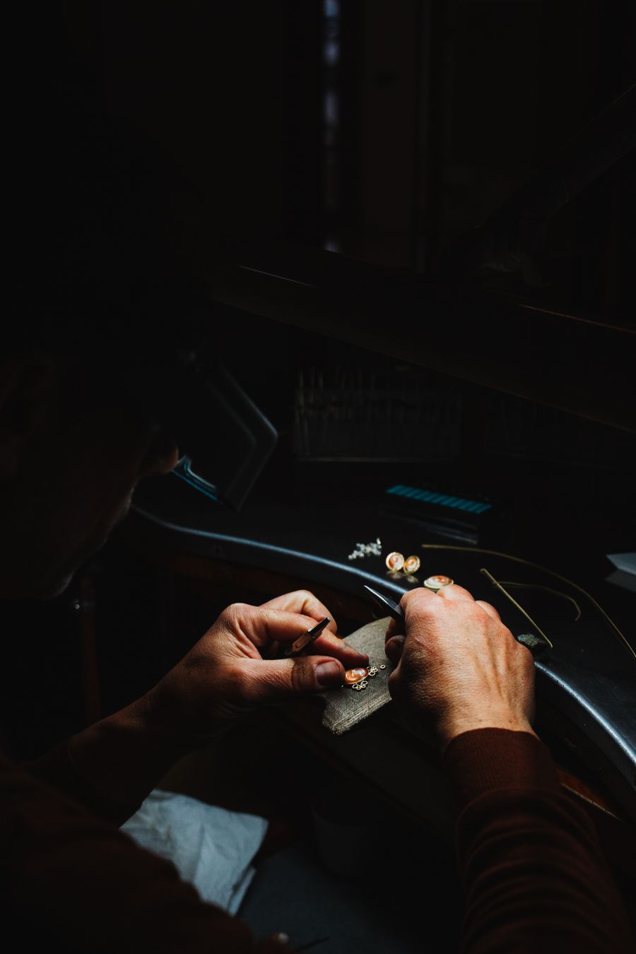 Artisan crafting jewelry in a dimly lit workshop