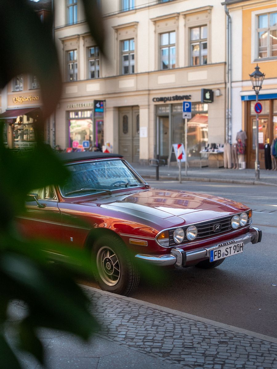 Classic red car on a cobblestone street