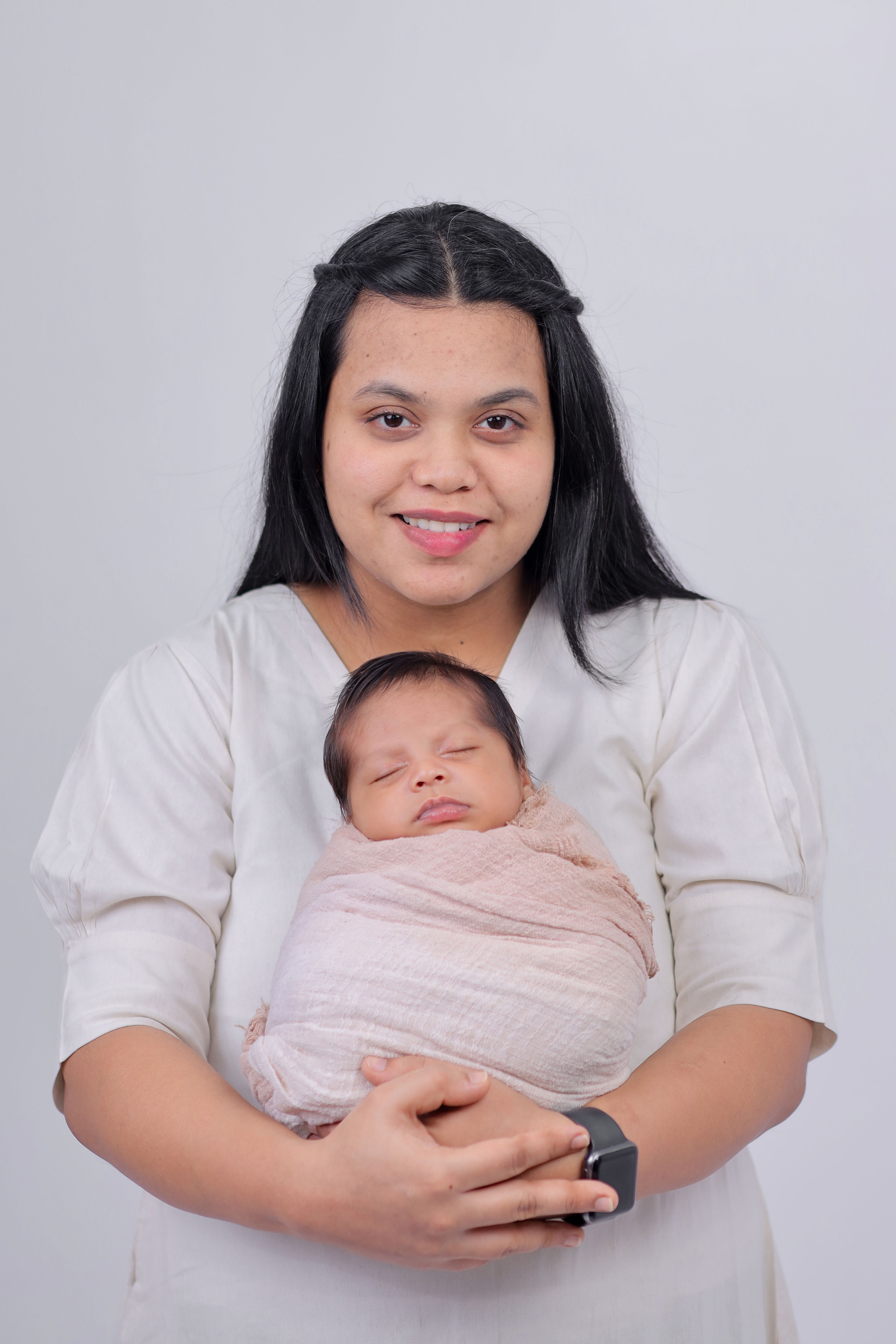 A serene portrait of a mother gently holding her newborn baby, wrapped in a soft blanket.