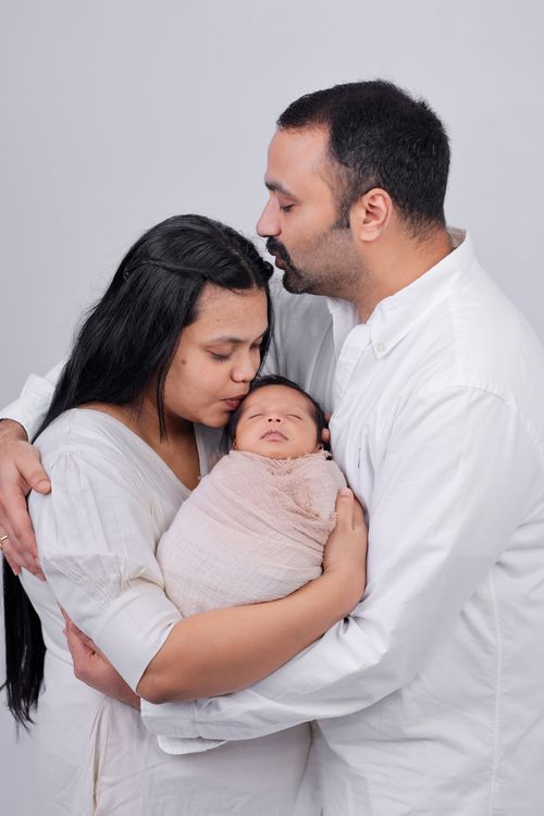 Free Tender moment of parents cherishing their newborn in a loving embrace. Stock Photo
