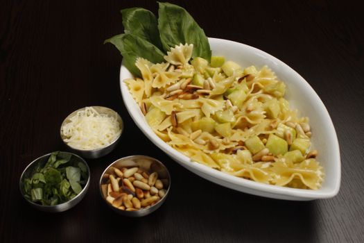 A tempting dish of farfalle pasta with zucchini, pine nuts, and fresh basil, perfect for a gourmet meal.