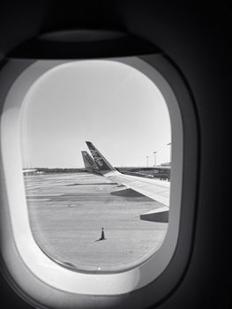 View from airplane window showing aircraft wing and airport runway in Selangor, Malaysia.