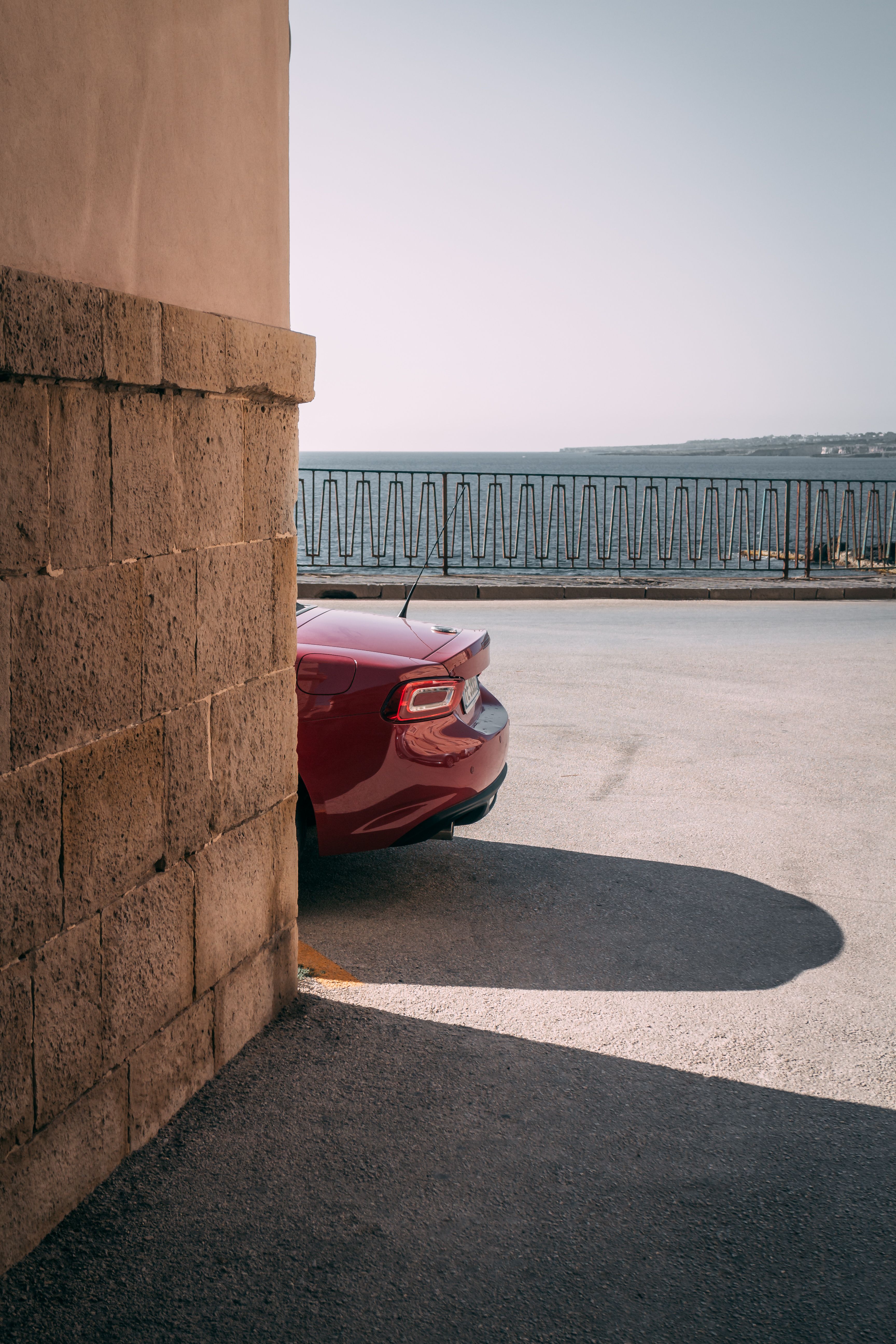 Red Car Parked by Seaside Coastal View · Free Stock Photo
