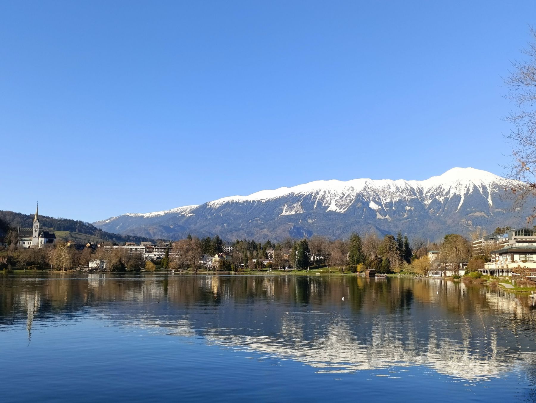 Lake Bled with mountains and the island church reflected in the water