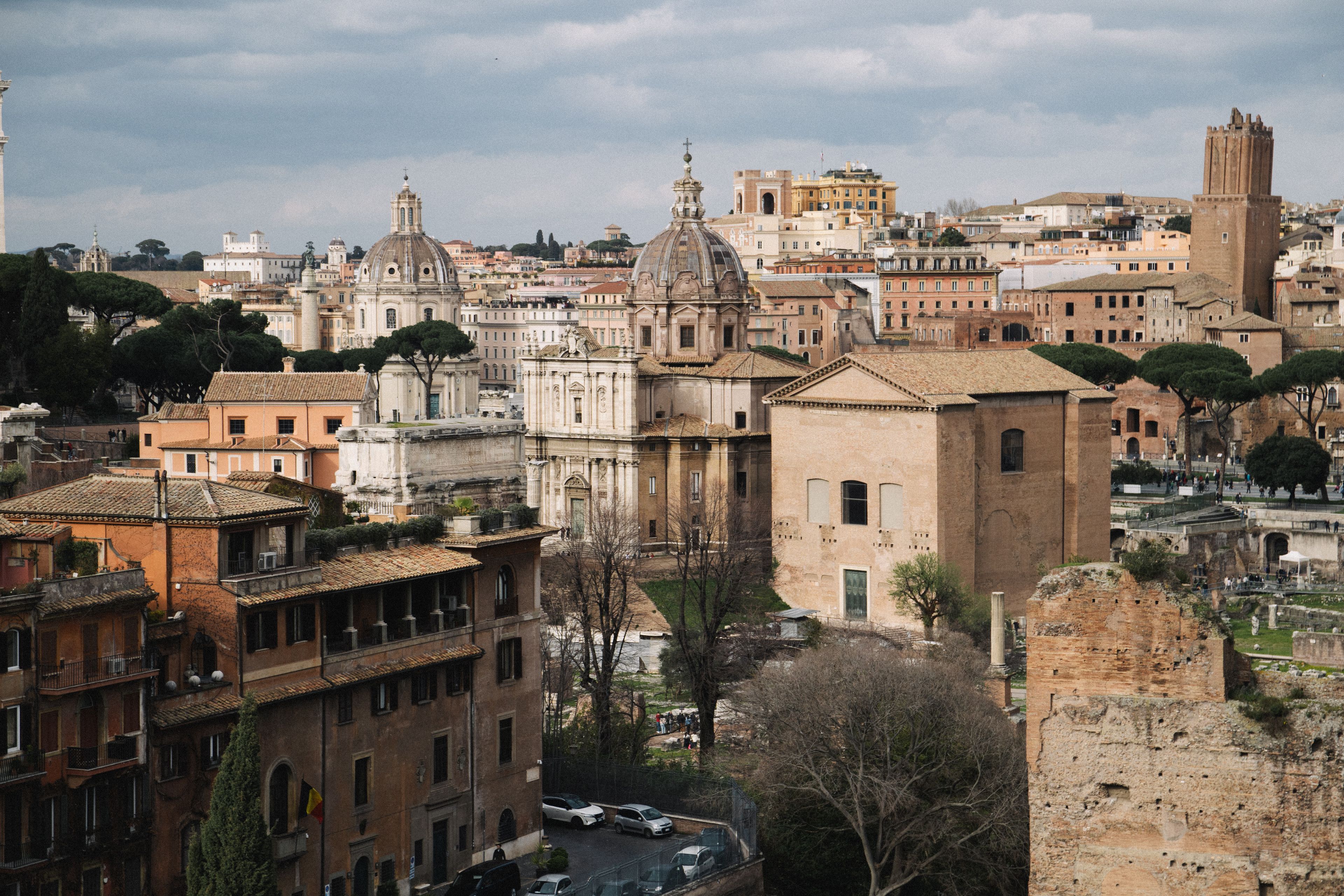 A captivating view of Rome's historic architecture including ancient Roman buildings under a cloudy sky.