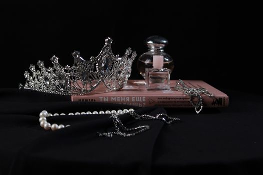 Jewelry and perfume elegantly arranged on a black background for a luxurious theme.