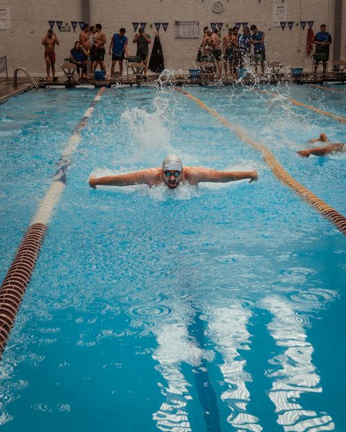 Free Swimmer performing butterfly stroke at a competitive indoor event in San Luis Potosí, Mexico. Stock Photo
