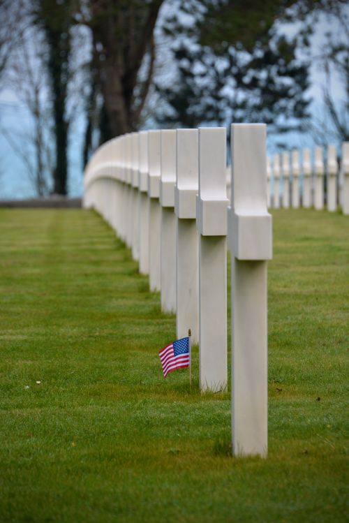 Free Row of memorial crosses with an American flag at a Normandy cemetery. Stock Photo