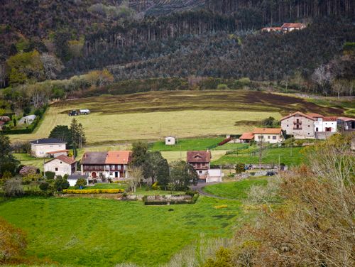 Free A scenic view of a rural village and farmland set in lush greenery. Stock Photo
