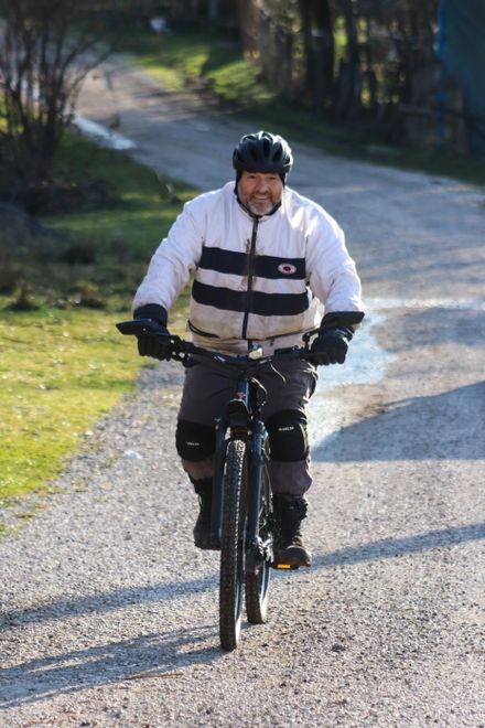 Cyclist riding a gravel path through sunny countryside — photo by Gizem Gökce on Pexels