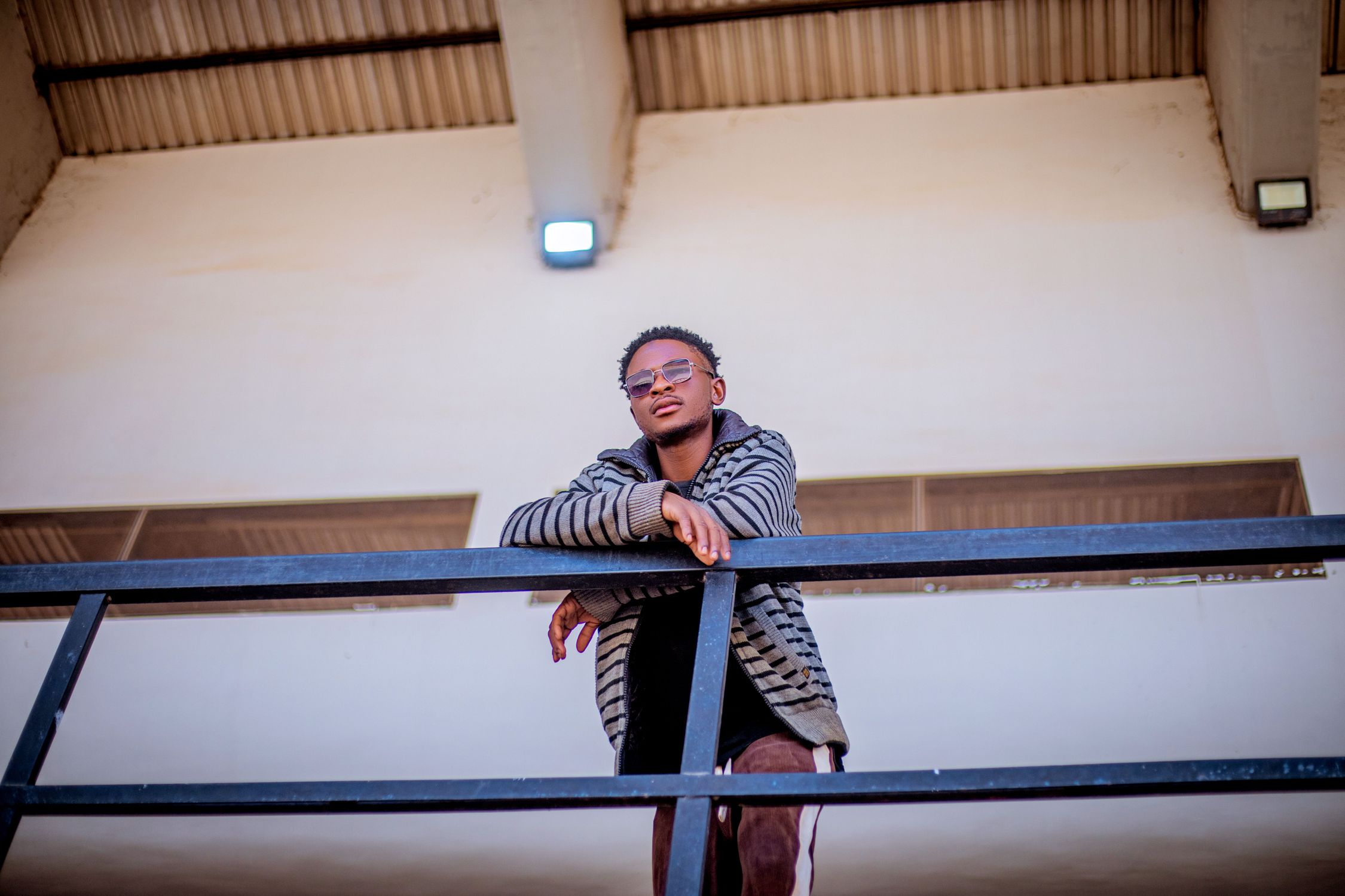 Stylish Young Man Leaning on Railing Outdoors · Free Stock Photo