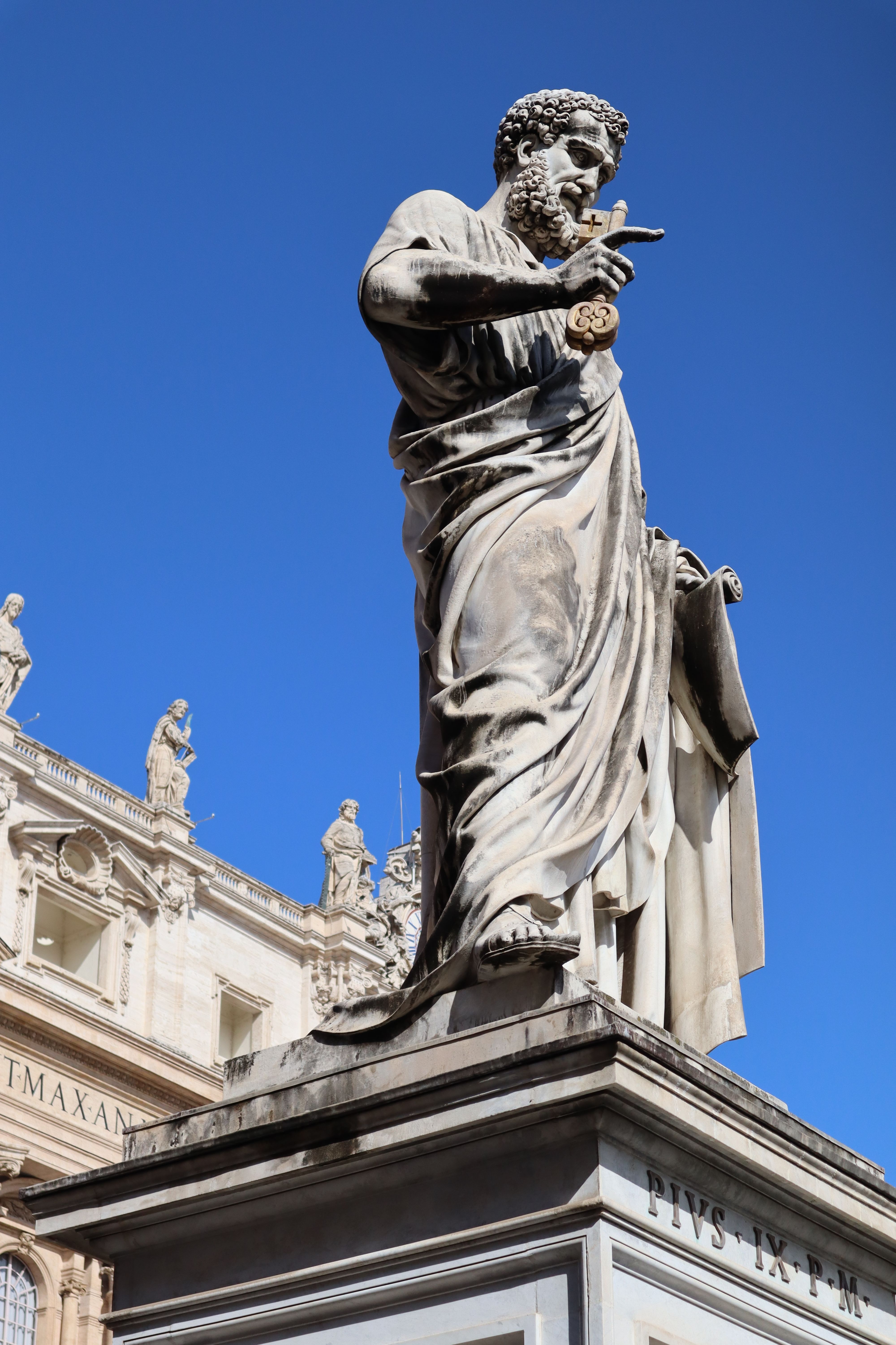 Majestic statue of St. Peter in Vatican City with striking blue sky backdrop.