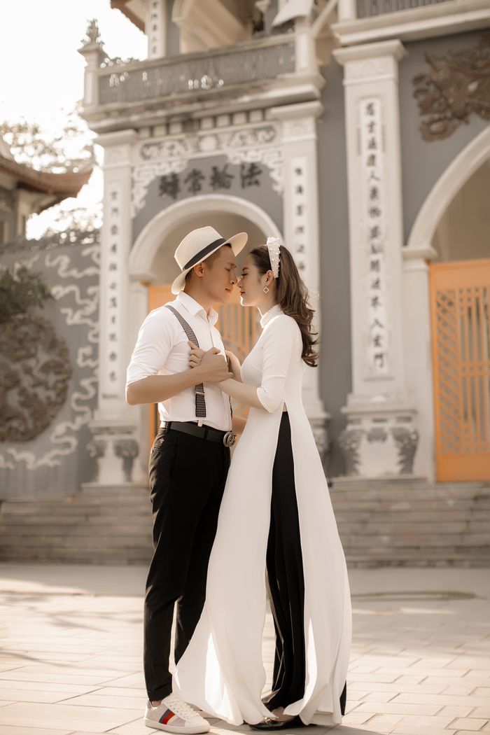 Cô dâu chú rể âu yếm trước cổng đền