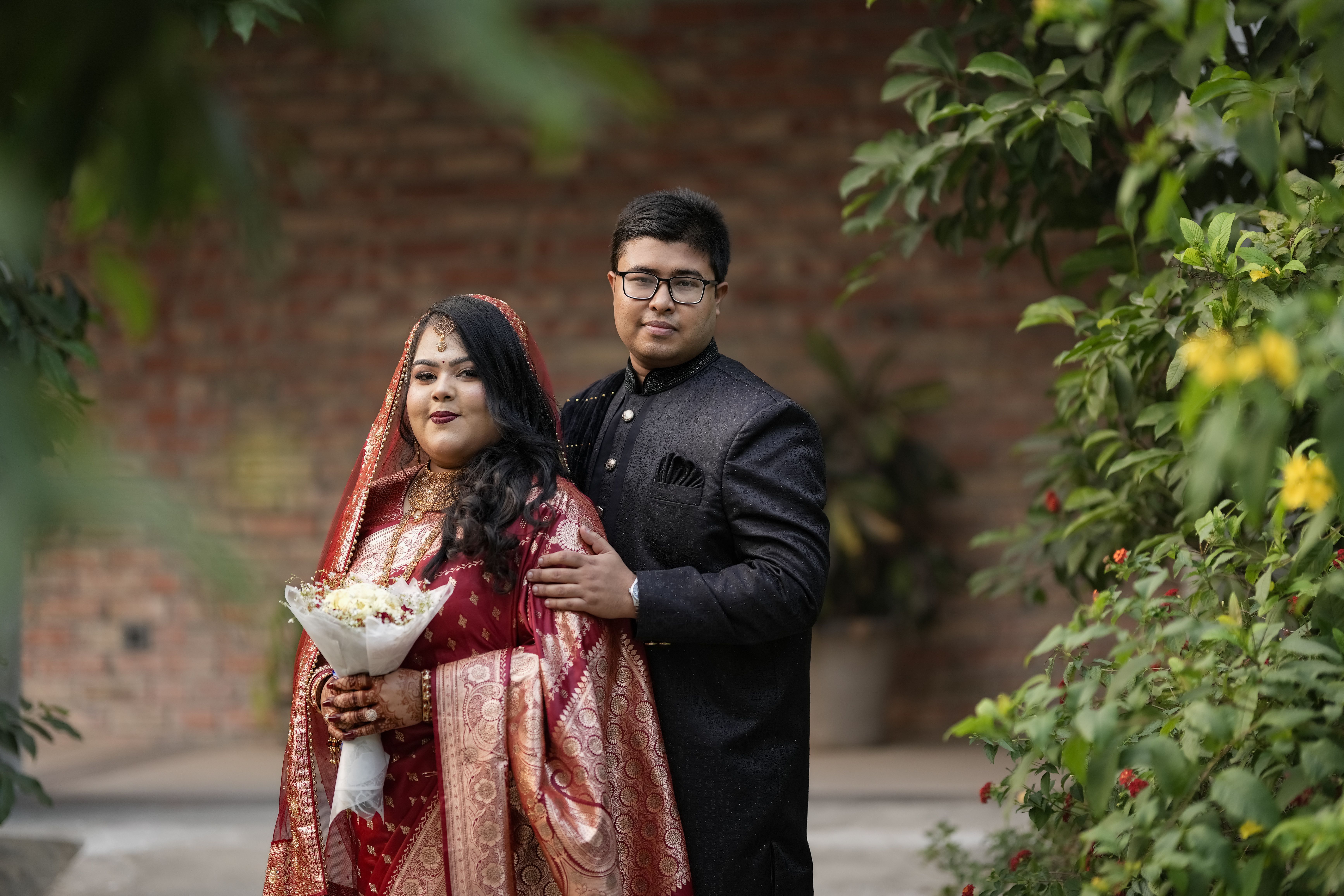 無料 美しいインド人カップルが、伝統的な衣装を身にまとい、屋外で結婚式を祝ってポーズをとっている。 写真素材