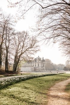 Idyllic morning view of Chateau de Chantilly with blooming gardens in France.