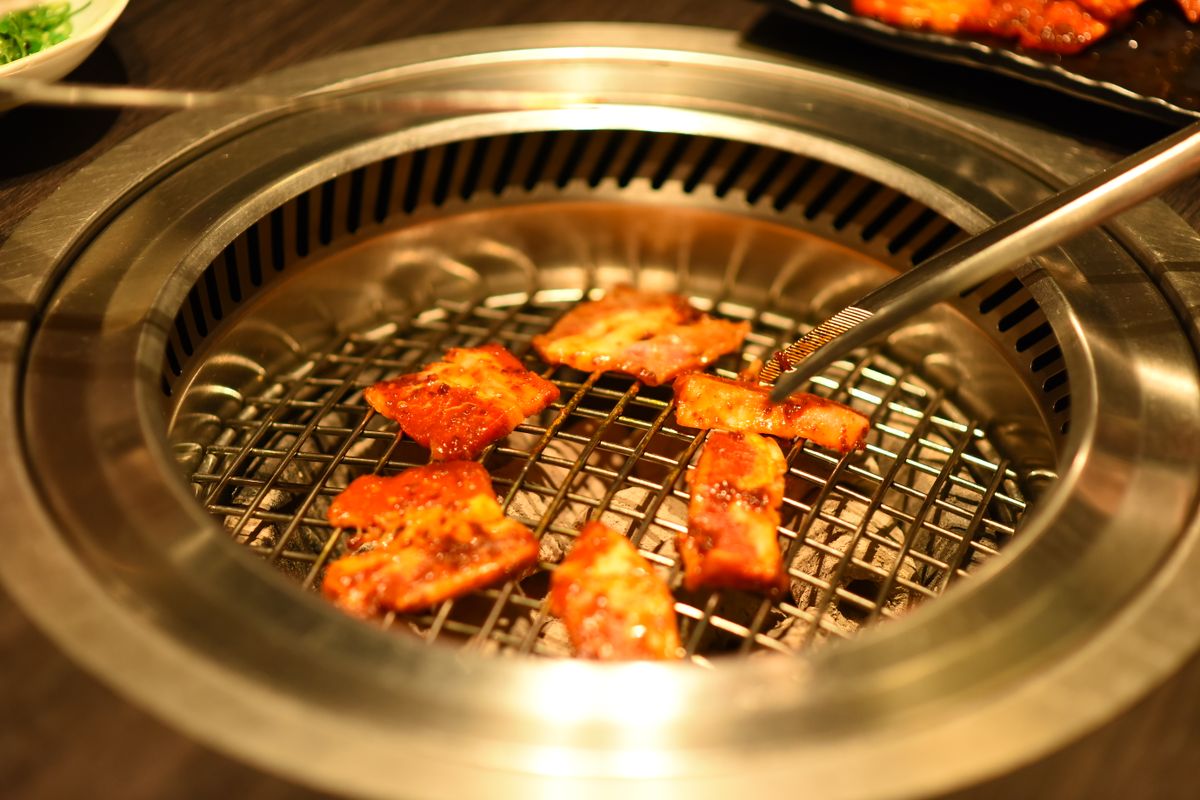 Food cooking on a shared grill. Ask about preparation and shared utensils rather than judging by appearance.