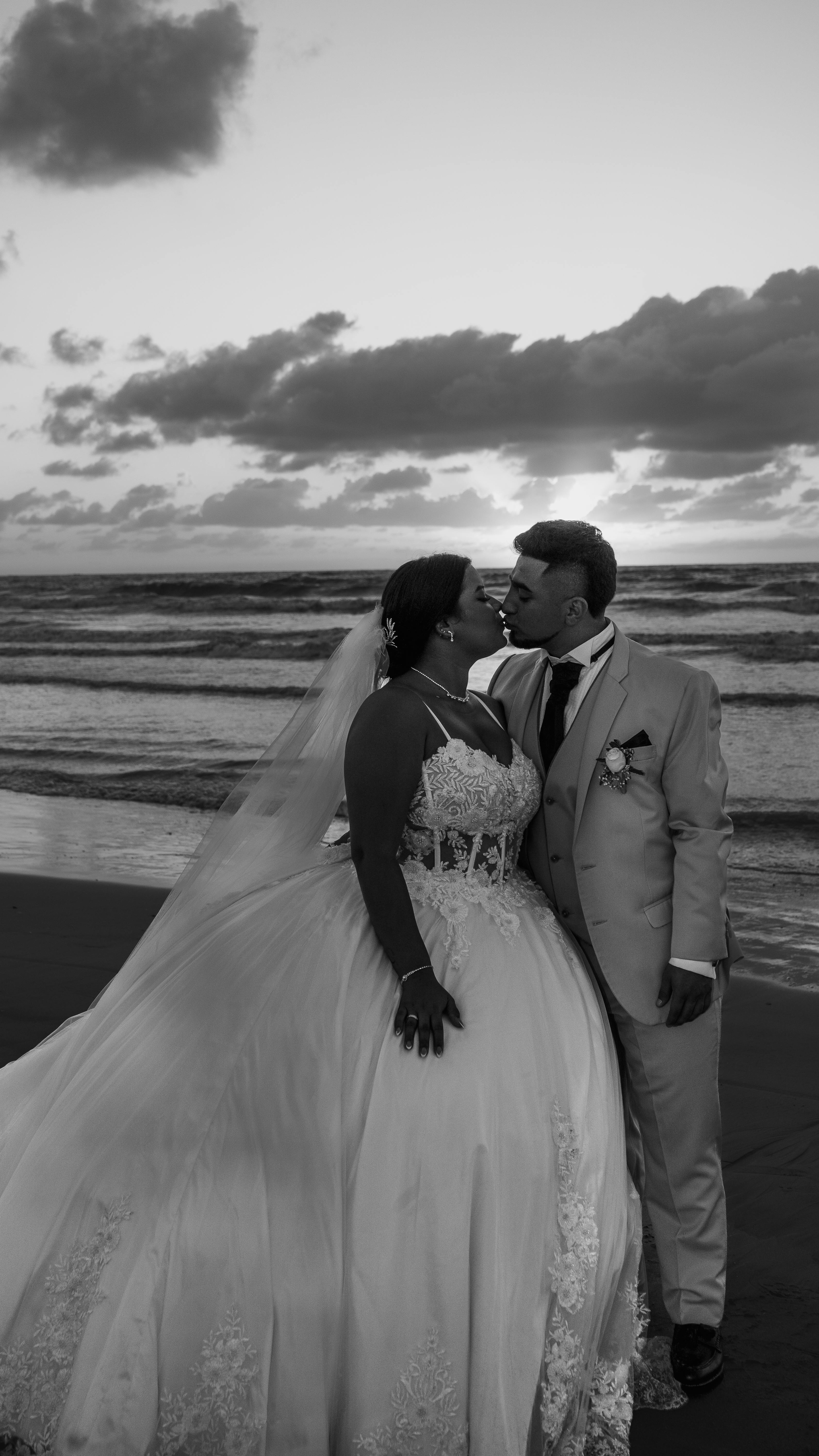 Couple sharing intimate moment on beach during stunning sunset wedding.