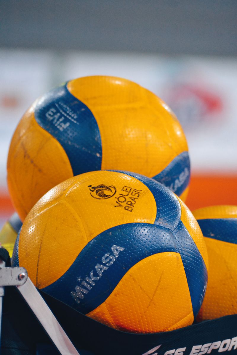 Colorful volleyballs lined up in a sports setting