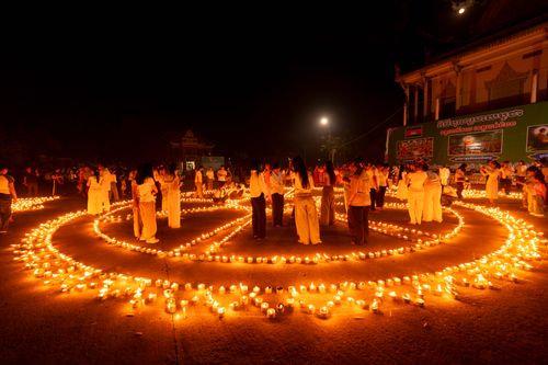 Free A captivating night scene of a candlelight ceremony with people gathered around a peace symbol in Battambang, Cambodia. Stock Photo