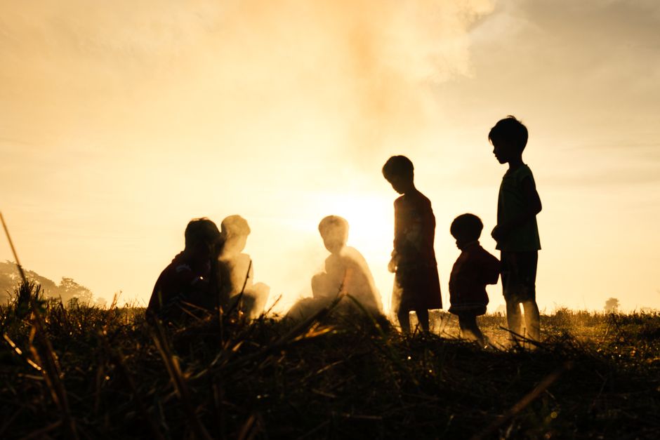 Silhouettes of children playing at sunset in Battambang Province, capturing a golden Cambodian evening.
