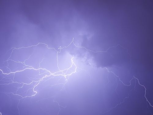 Free A vivid display of a lightning bolt illuminating a dark cloud-filled sky. Stock Photo