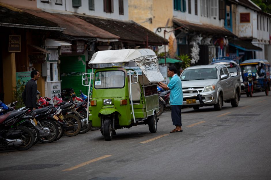 Traditional tuk-tuk parked near an ancient temple in Siem Reap, Cambodia.