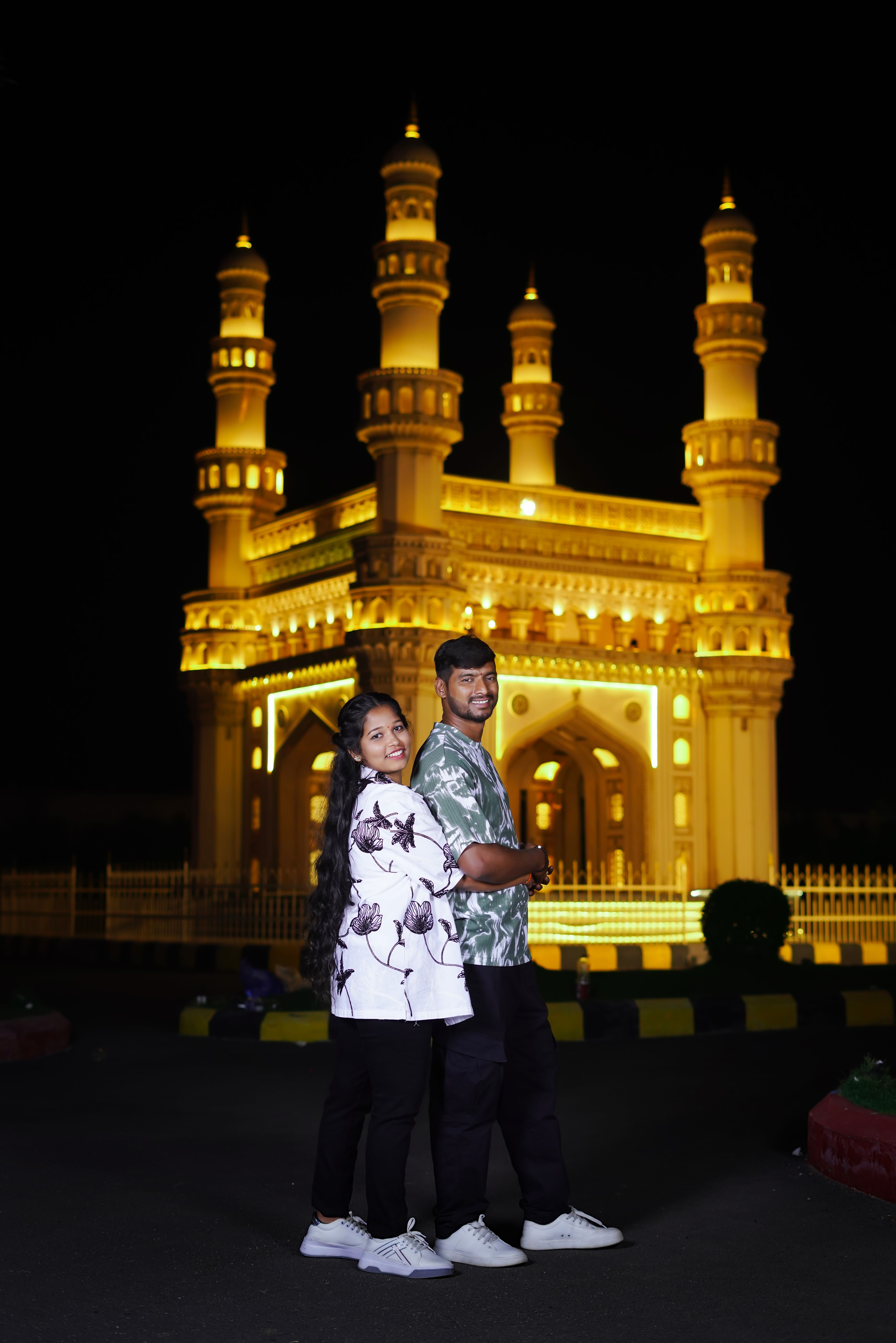 A couple poses in front of the illuminated Charminar in Hyderabad, India.